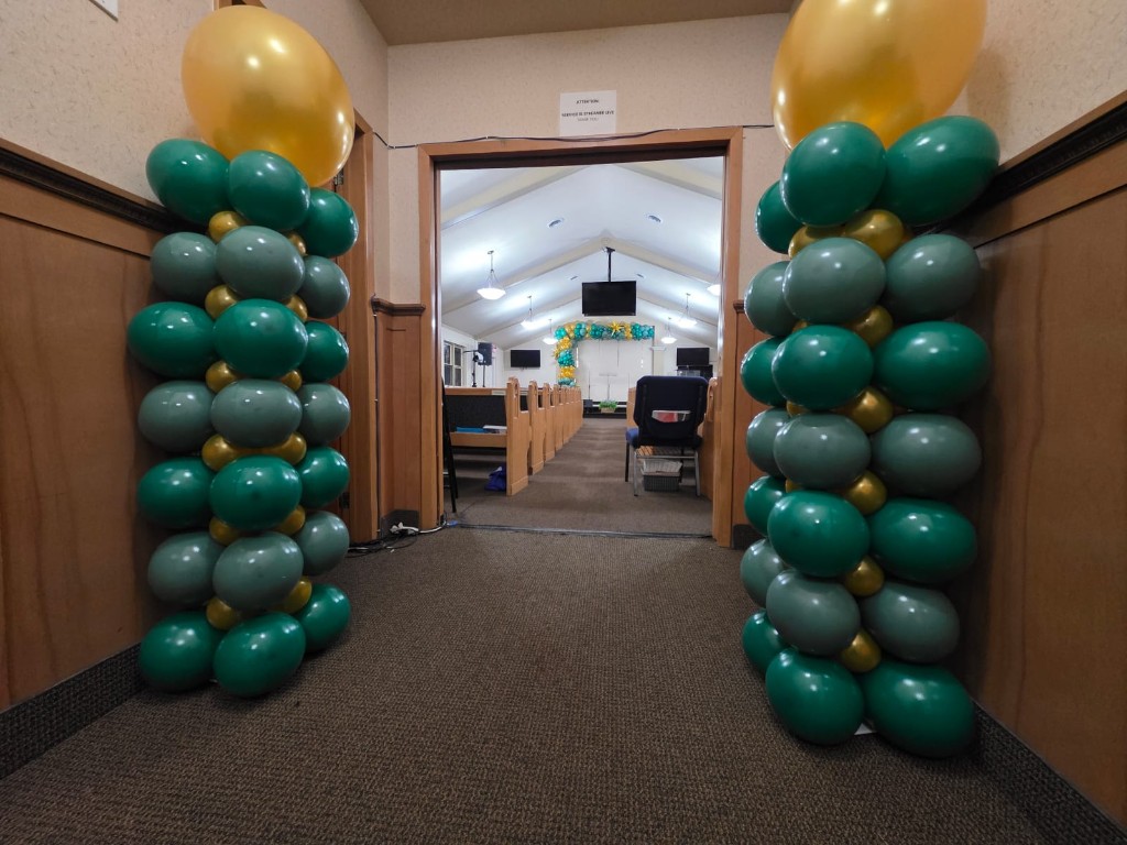 Green and gold balloon columns flanking a doorway
