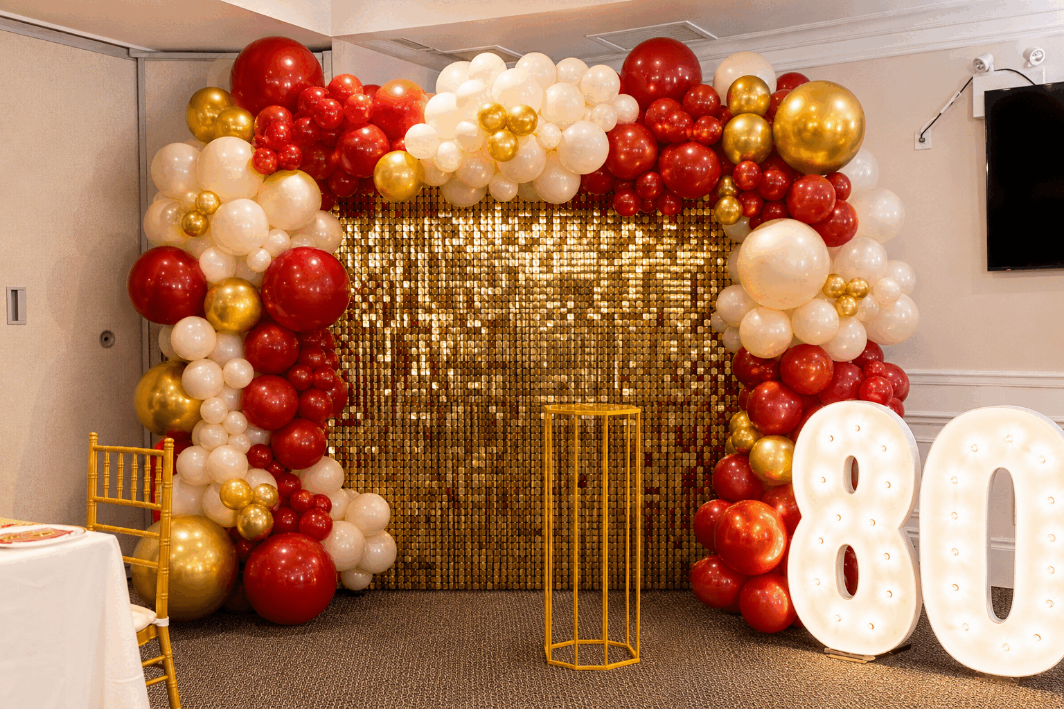 Royal red balloon installation with gold accents