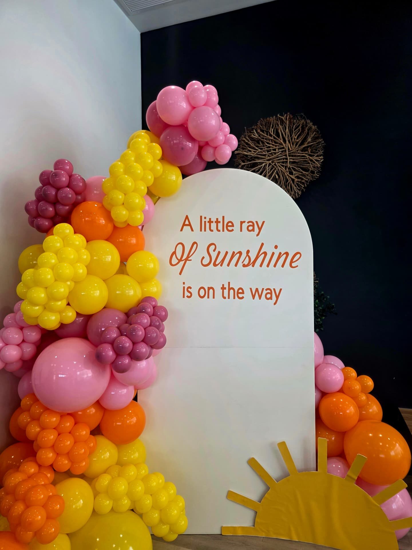 "A little ray of sunshine" baby shower arch in pink, yellow and orange